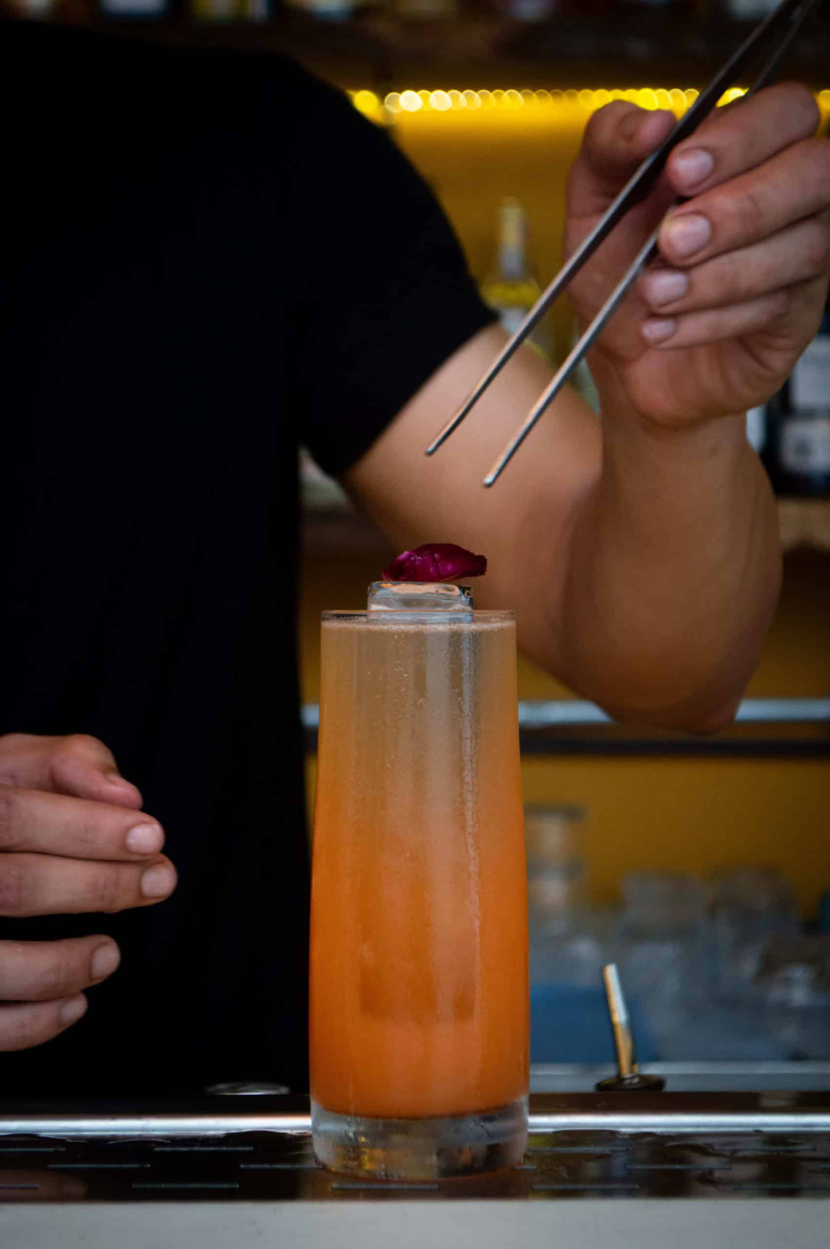 foto mostra o bartender finalizando o drink