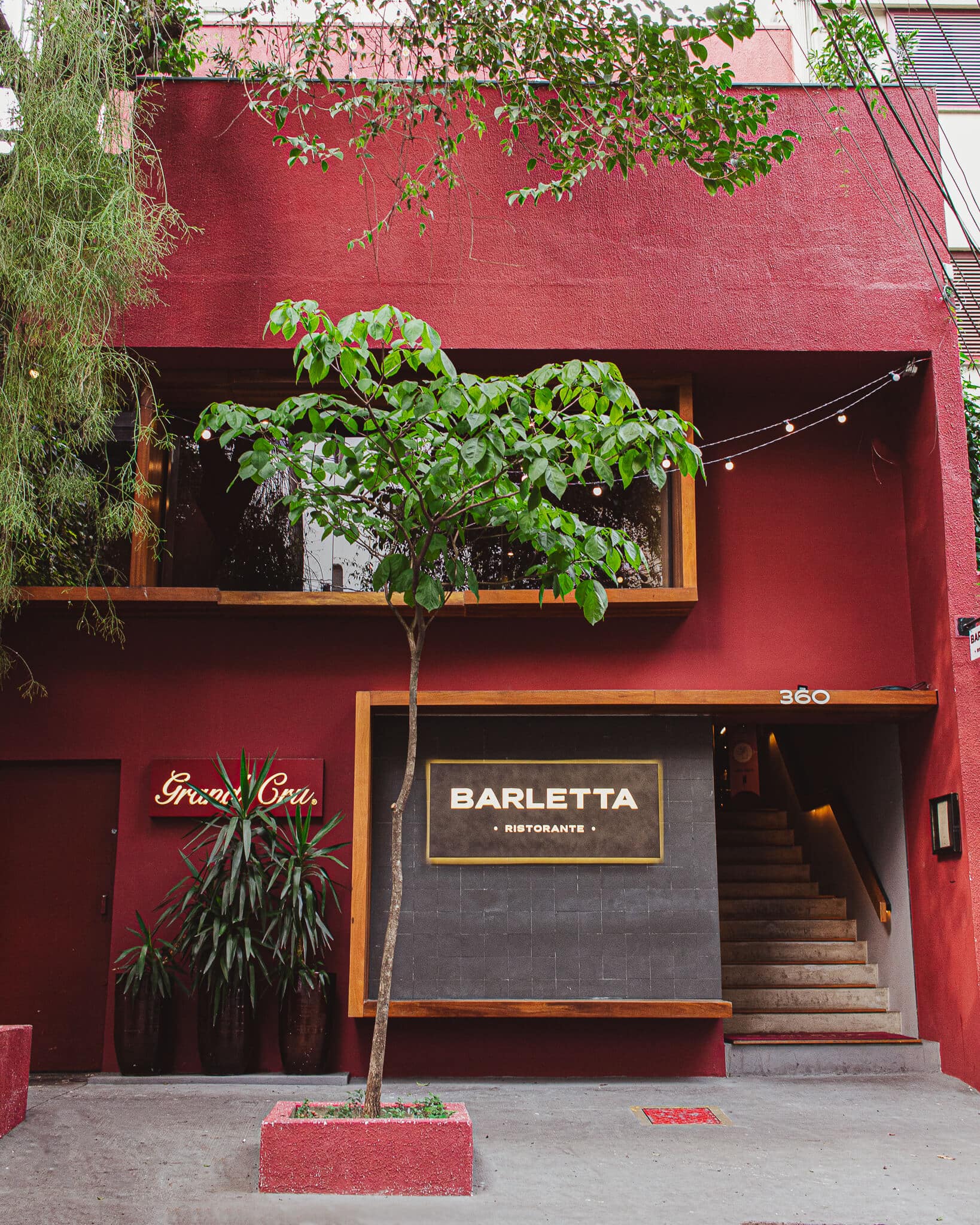 foto mostra a fachada do barletta ristorante, com muros vermelhos e arborizado