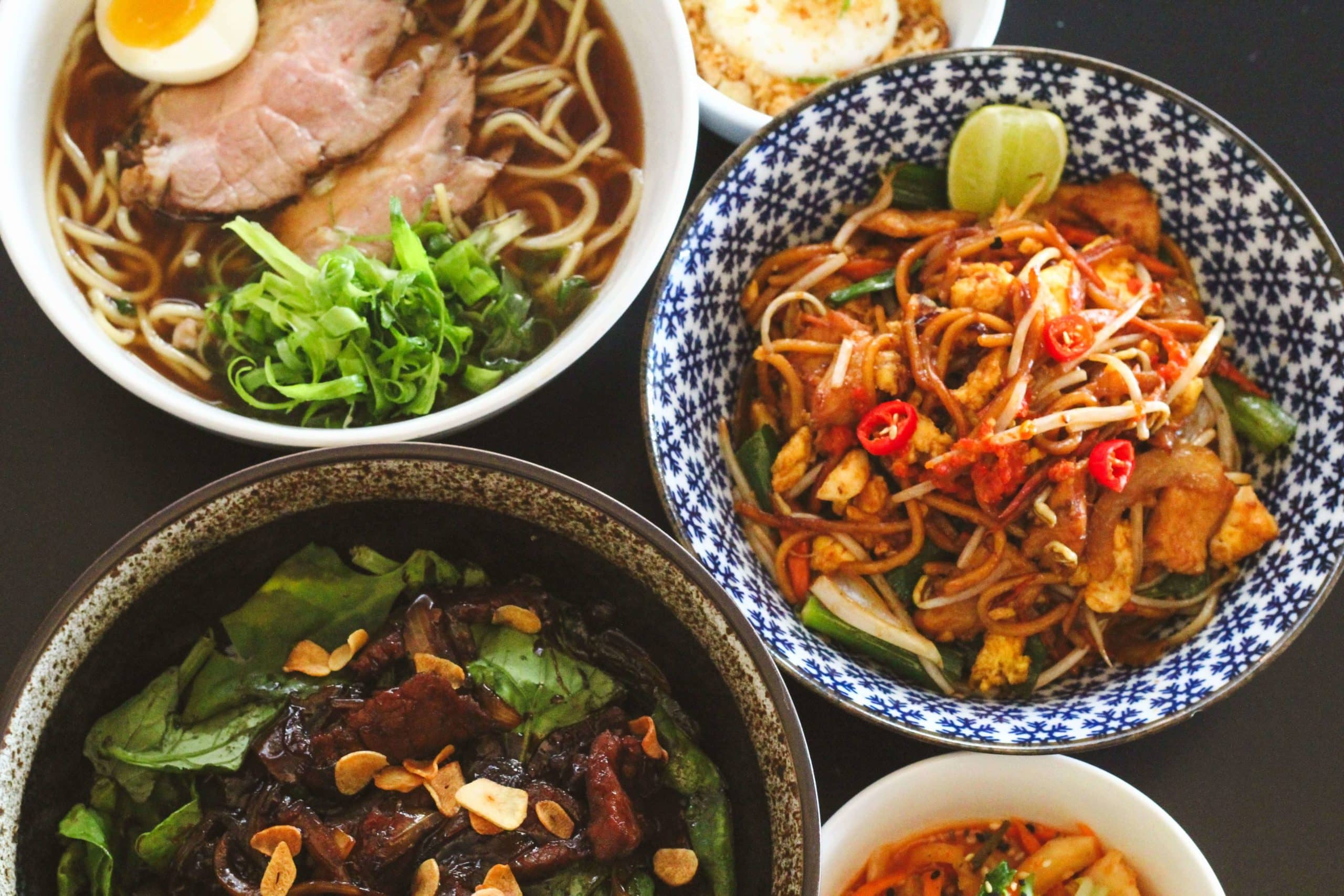 Foto contem três pratos principais do Jui um ao lado do outro. Beef Wok, Ramen e Mee Goreng.