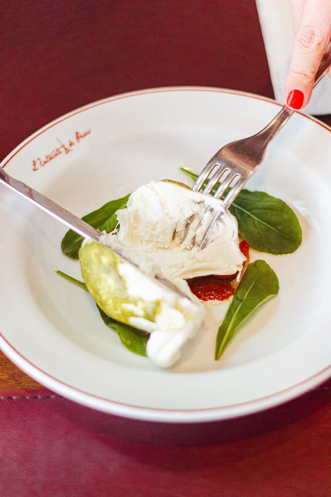 foto mostra uma pessoa cortando a burrata de bufala e mostrando seu interior