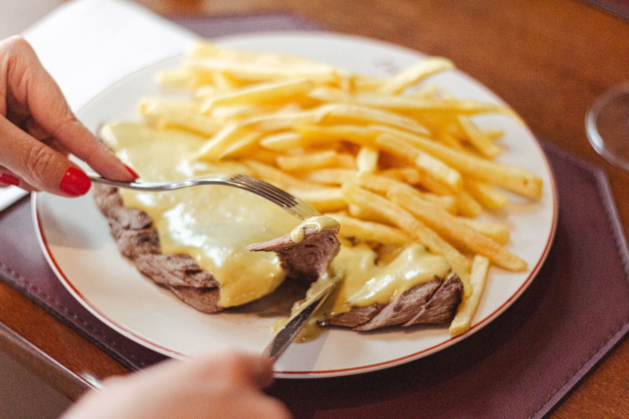 foto mostra uma pessoa cortando o entrecote e mostrando o ponto da carne