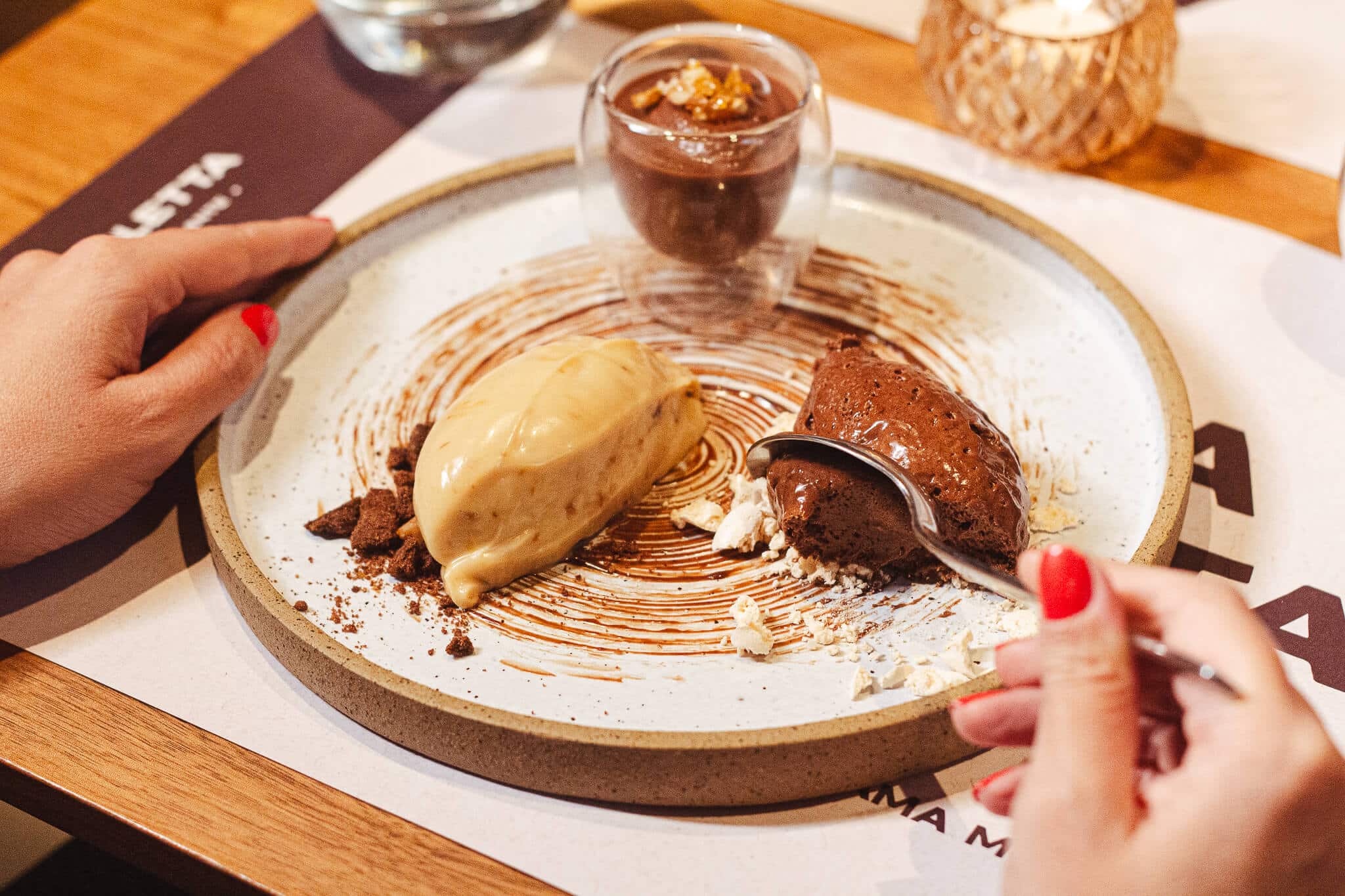 foto mostra uma pessoa comendo com uma colher a sobremesa trio de chocolates do barletta ristorante