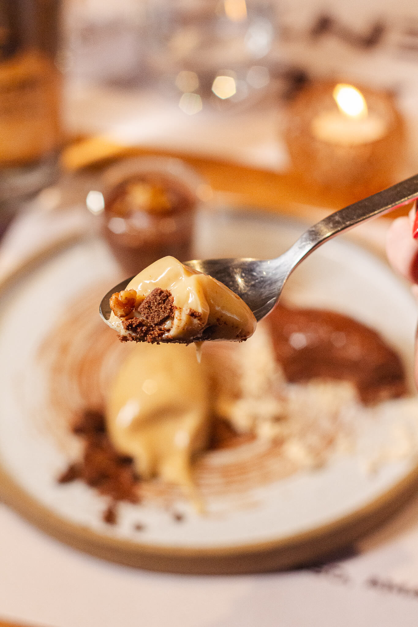 foto mostra uma pessoa segurando uma colher com um pedaço da sobremesa trio de chocolates do barletta ristorante.